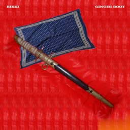 Sheathed asian sword and a blue handkerchief lying on red fabric